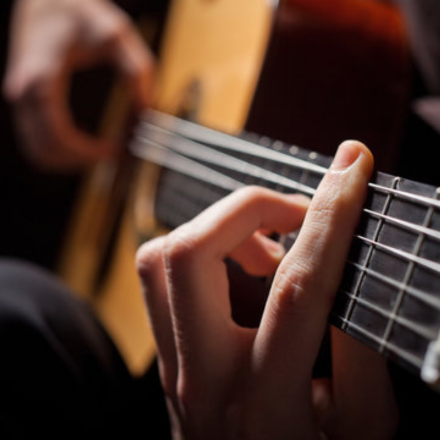 man playing guitar closeup 440x440px